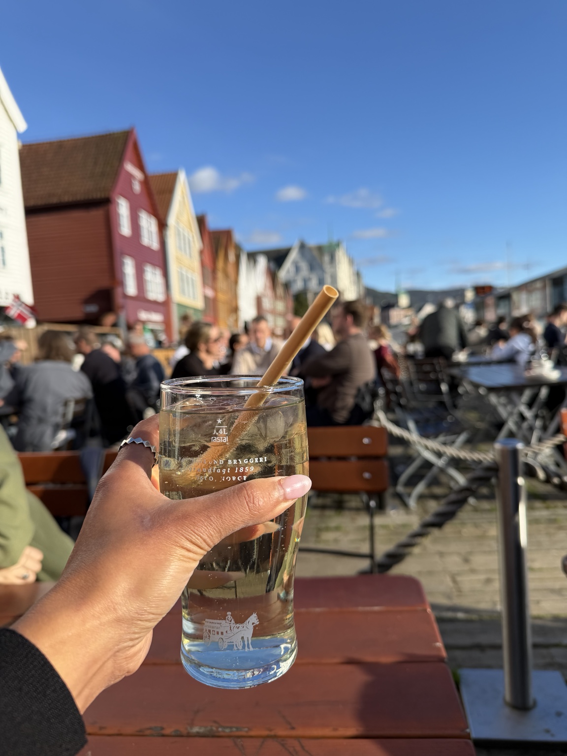 A drink at an outdoor bar overlooking the colorful Bryggen buildings in Bergen